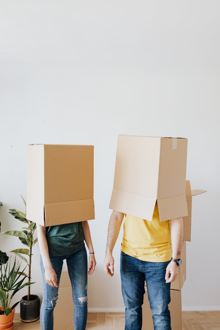 Young couple having fun with boxes while moving into a new apartment.